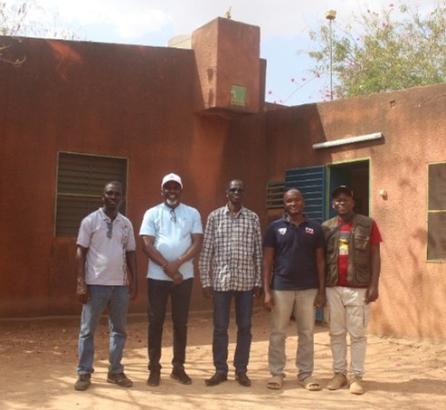 Five men standing in front of a house.