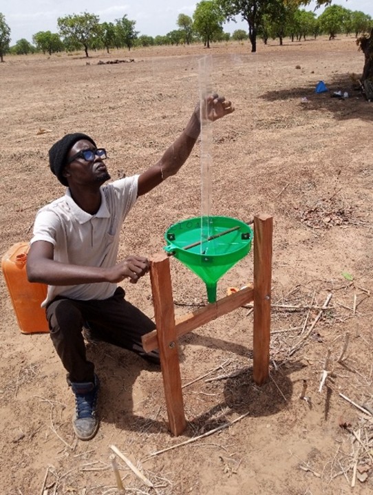 Men working with a tool to collect arthropods. The tool is made of wood with a green funnel on top